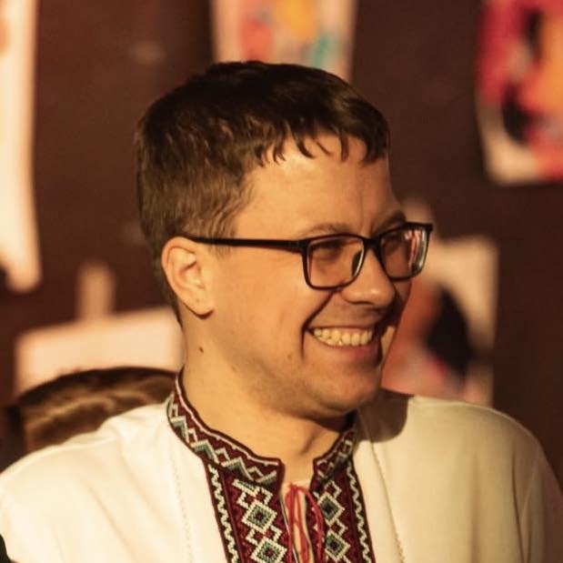Igor Sulim uśmiechnięty młody mężczyzna w okularach i wyszywanej koszuli